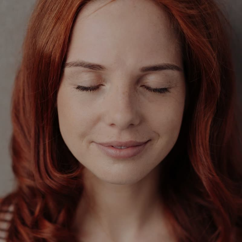 Uma mulher de olhos fechados em pausa, respirando