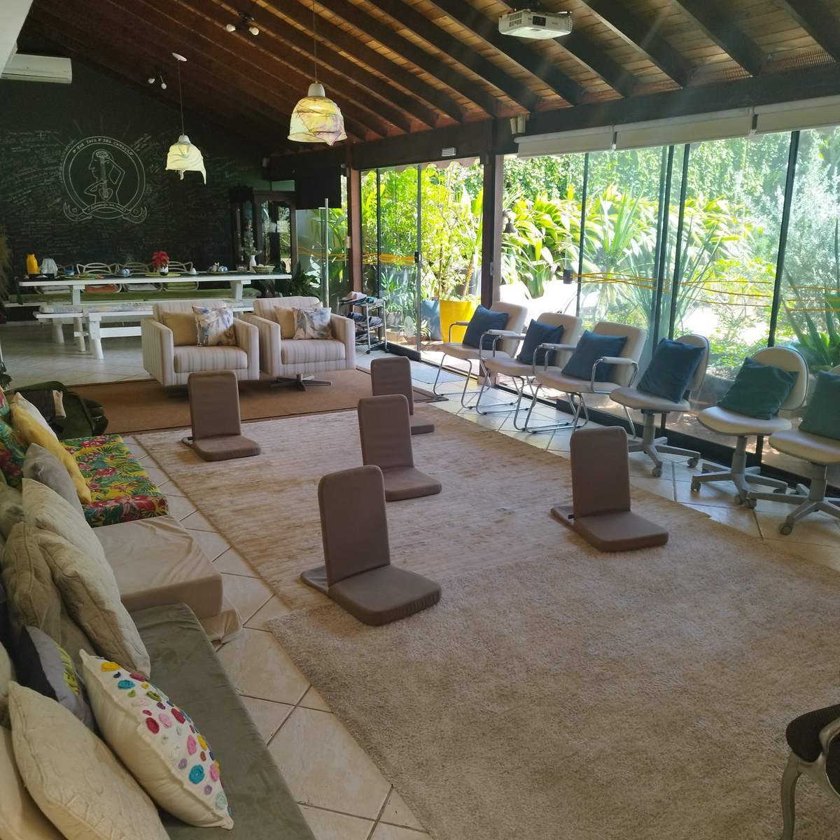 O salão com as paredes de vidro abertas para o jardim